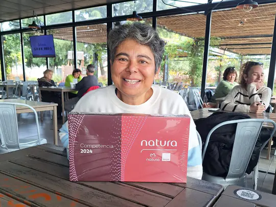 Una consultora sonriente con la caja de la Competencia 2024 de Natura